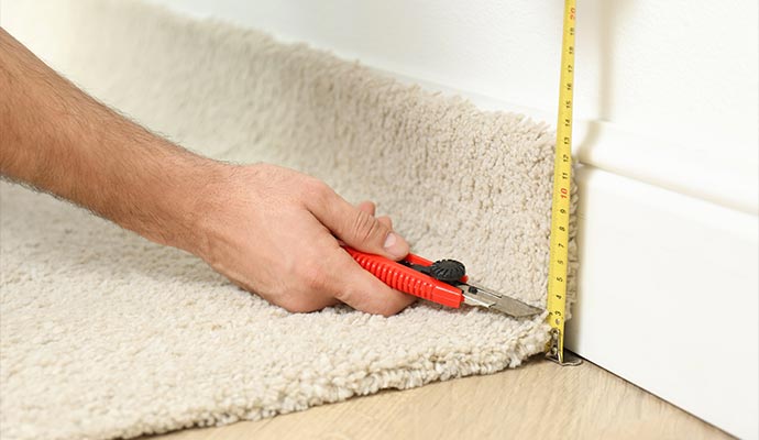 https://www.kleandry.com/images/worker-with-cutter-knife-and-measuring-tape-installing-carpet-tack-strip-replacement-and-repair.jpg